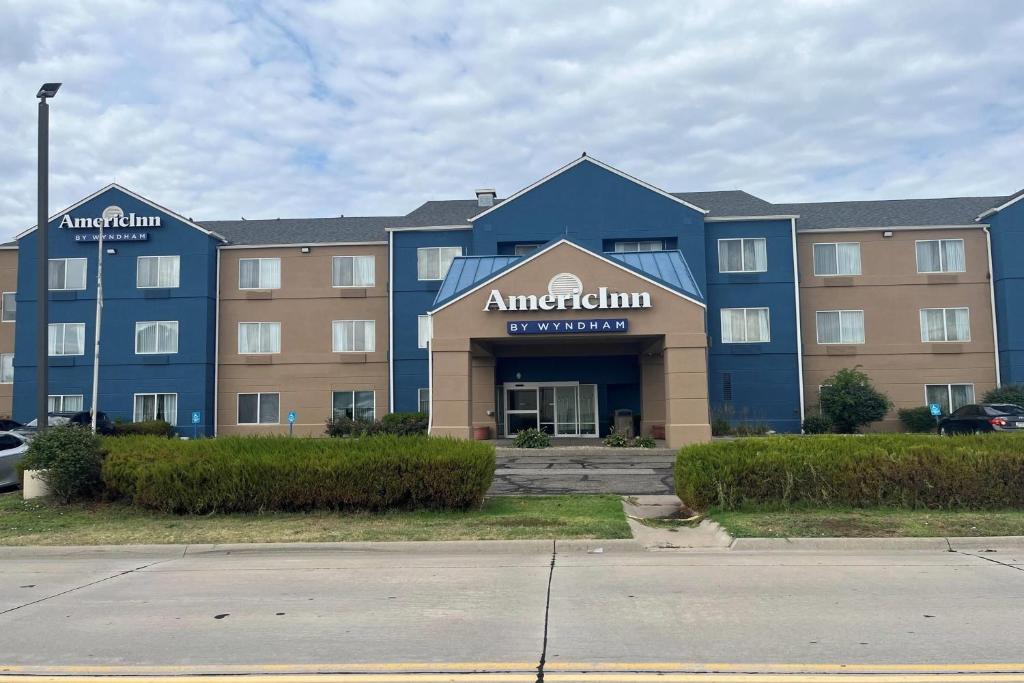 a large blue building with an ant hospital sign on it at AmericInn by Wyndham Hays in Hays