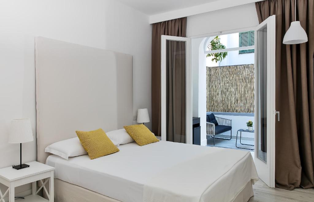 a white bedroom with a bed and a balcony at Fuorlovado 40 in Capri