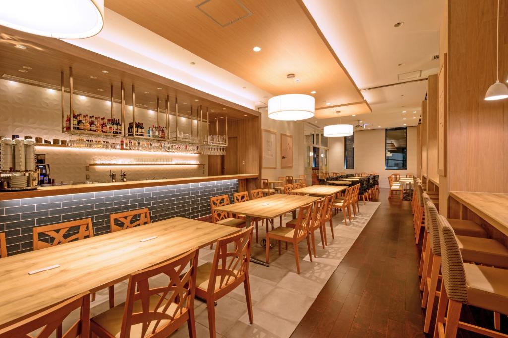 a restaurant with wooden tables and chairs and a bar at Hotel Mystays Premier Akasaka in Tokyo