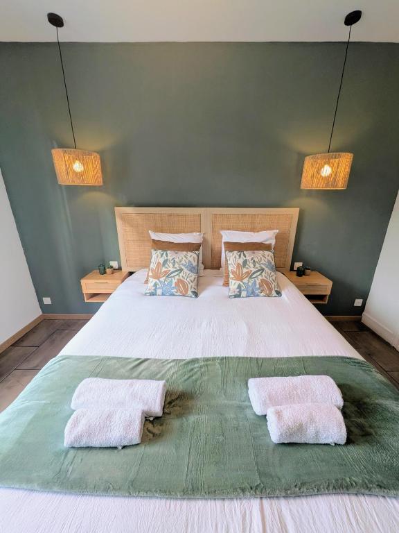 a bedroom with a large bed with two towels on it at Le 1930, la pause Béthunoise in Béthune
