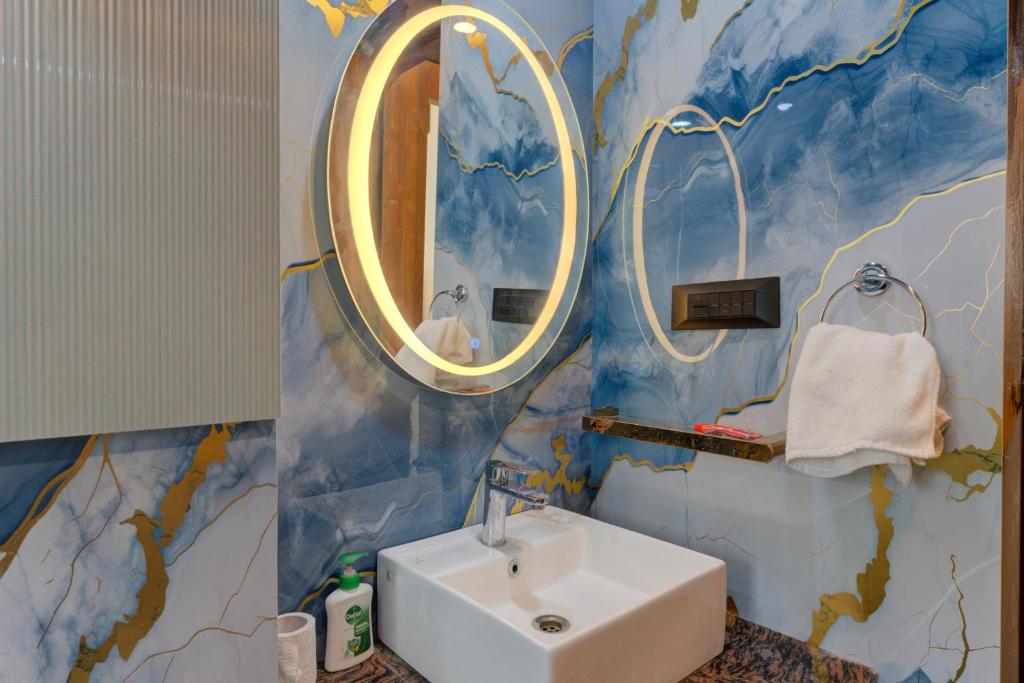 un baño con lavabo y espejo en Sunworld Arista, en Noida