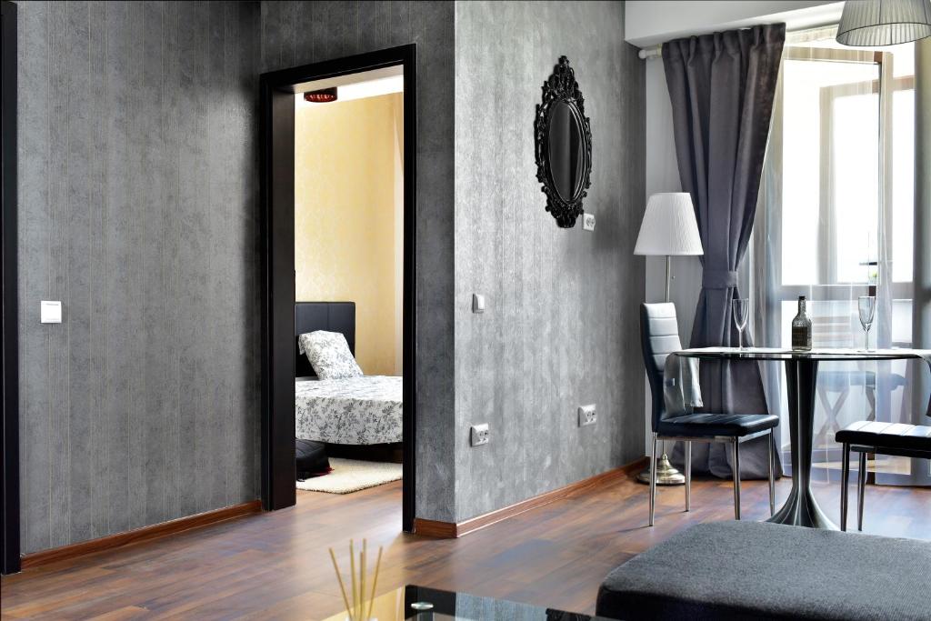 a living room with a mirror and a table at Palace Central Suites in Iaşi