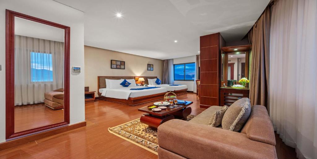a hotel room with a bed and a couch at Sandals Stay Hotel in Da Nang