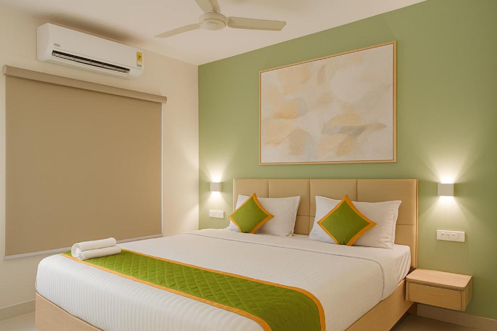 a bedroom with a large bed with green walls at Elegant Residency in Coimbatore