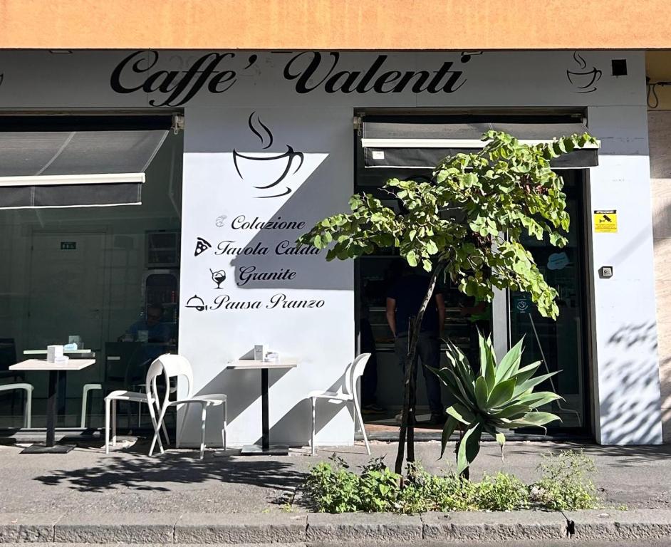a cafe with tables and chairs in front of a building at Berht - Appartamenti al centro di Catania in Catania
