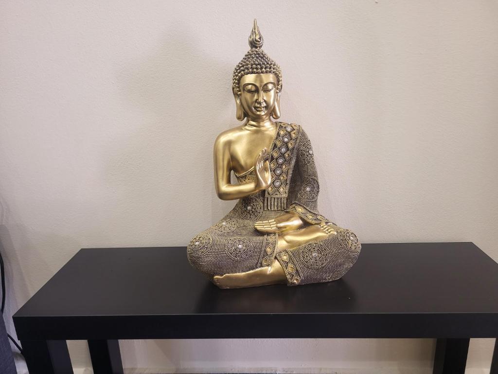 een bronzen beeld van een boeddha zittend op een tafel bij Artemis Home Alexandroupolis Spa and Relax in Alexandroupoli