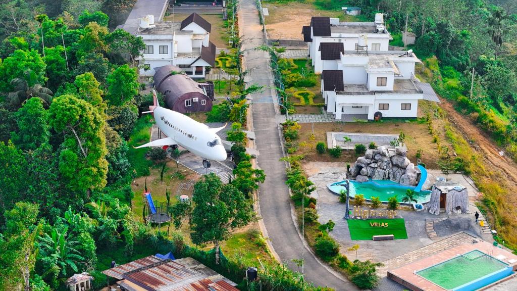 バガモンにあるHighrange Villasの大きな飛行機が家の上を飛んでいる