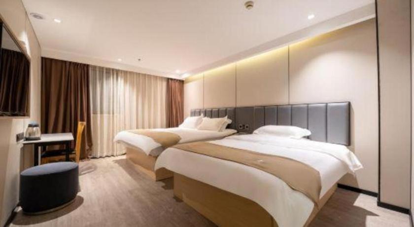 a hotel room with two beds and a desk at GreenTree Inn Shanghai Railway Station Macao Road in Shanghai