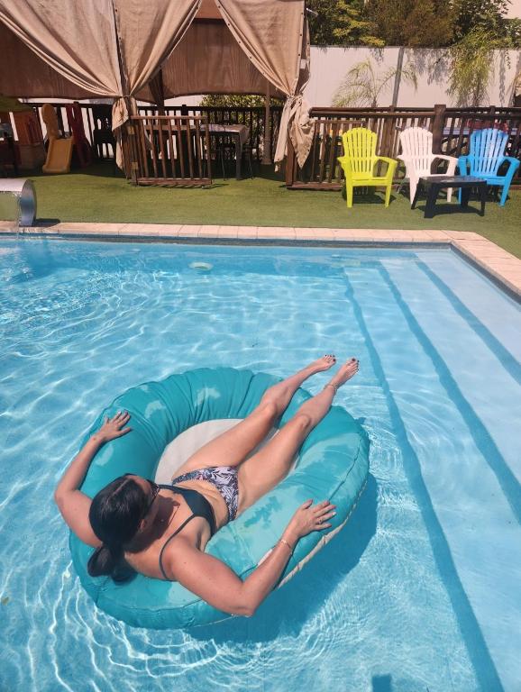 a woman is laying on anlatable raft in a swimming pool at צימר חן בחד נס in Had Nes