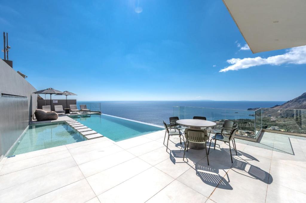 a patio with a table and chairs next to a pool at Dione Villa in Sellía