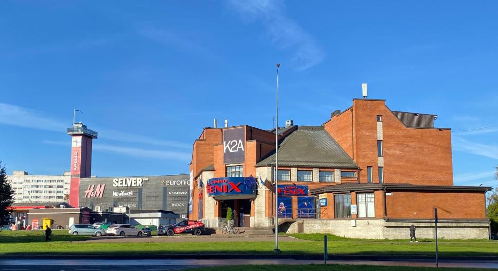 a large brick building with a water tower in the background at Narva Kangelaste 2 Apartments in Narva
