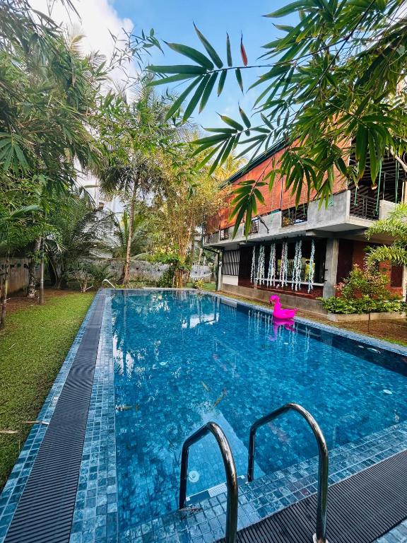 a swimming pool in front of a building at moments hotel & restaurant in Hikkaduwa