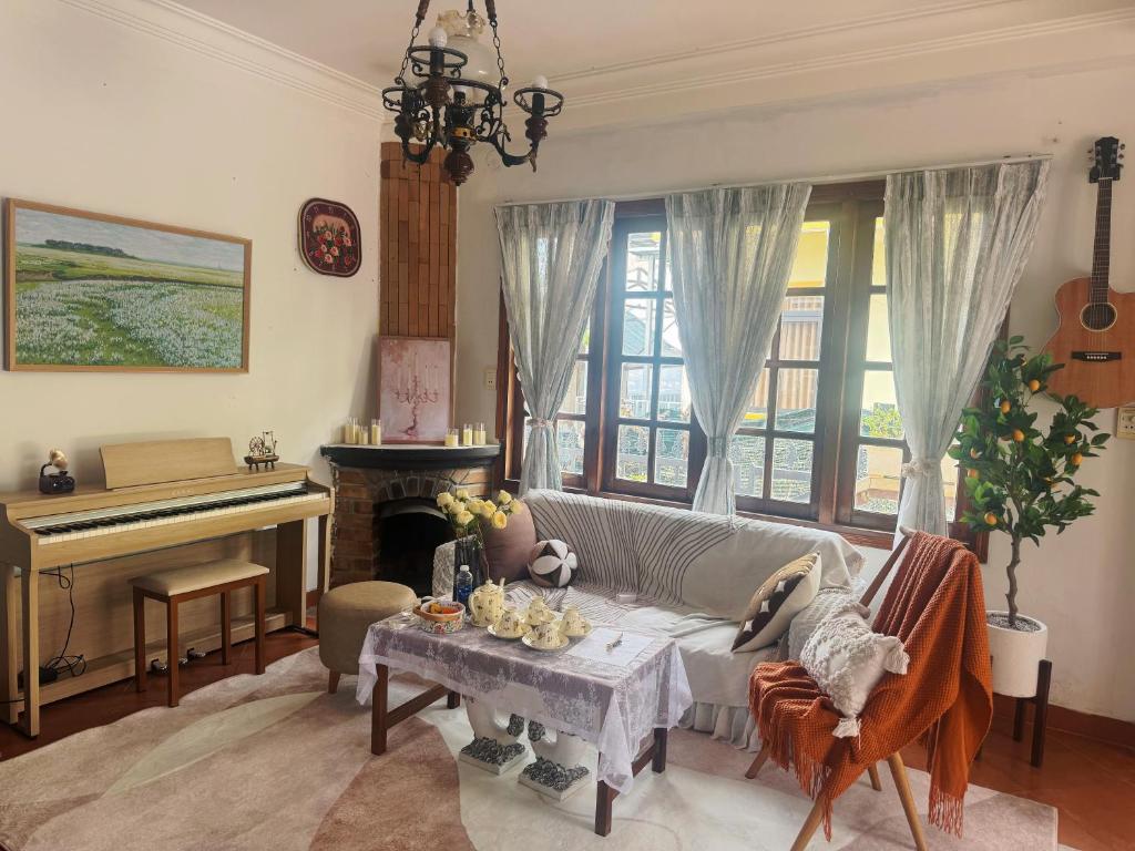a living room with a couch and a piano at nas dream homestay in Da Thanh