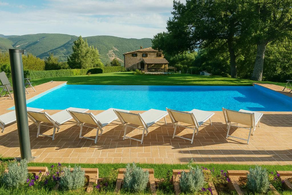 a group of chairs sitting next to a swimming pool at VILLA NASCA - Ville Carborello in Castelraimondo