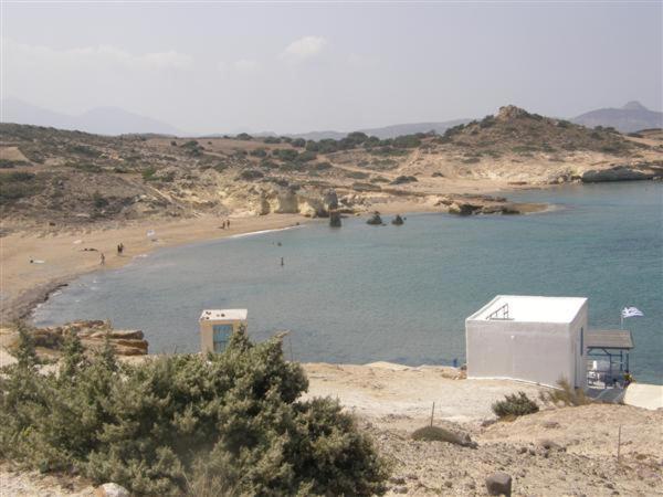 a body of water with a beach with people on it at Papafragas Studios in Pachaina