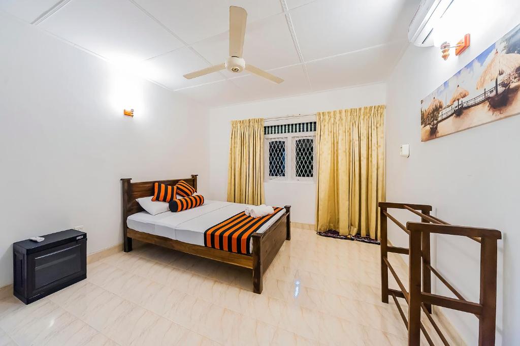 um quarto com uma cama e uma televisão de ecrã plano em Cloud Inn Kandy em Kandy