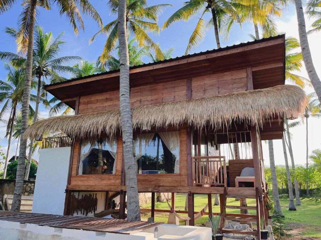 a house on the beach with a thatched roof at Living On Air in Pulau Sarang