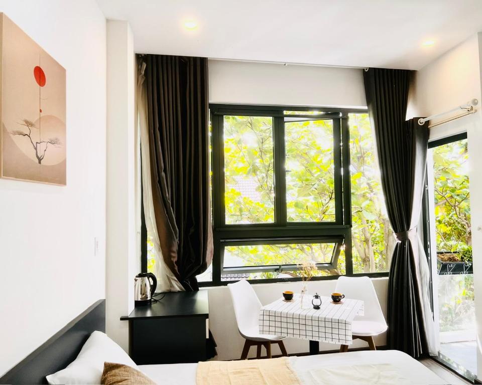 een kamer met een bed, een tafel en een raam bij Levi Living in Da Nang