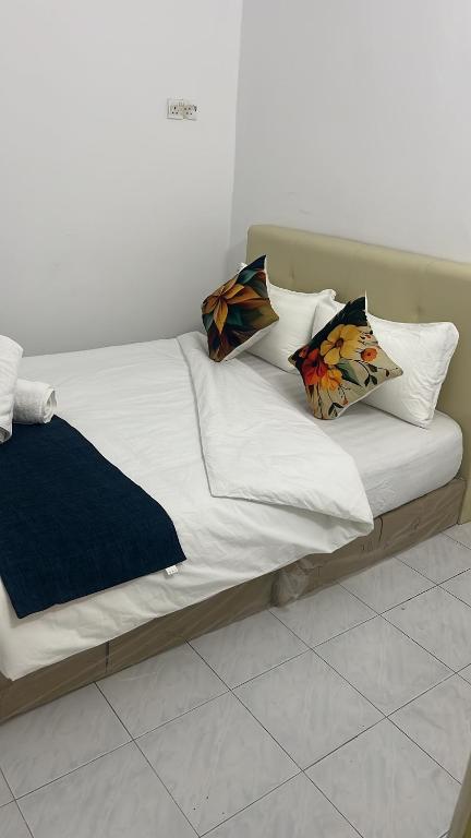 a bed with white sheets and pillows on it at Rest N Go CM in Ipoh