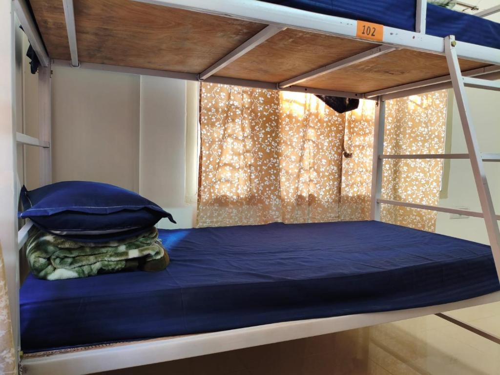 ein Etagenbett mit blauen Laken und Kissen darauf in der Unterkunft Tribal Hostel & Homestay in Guwahati
