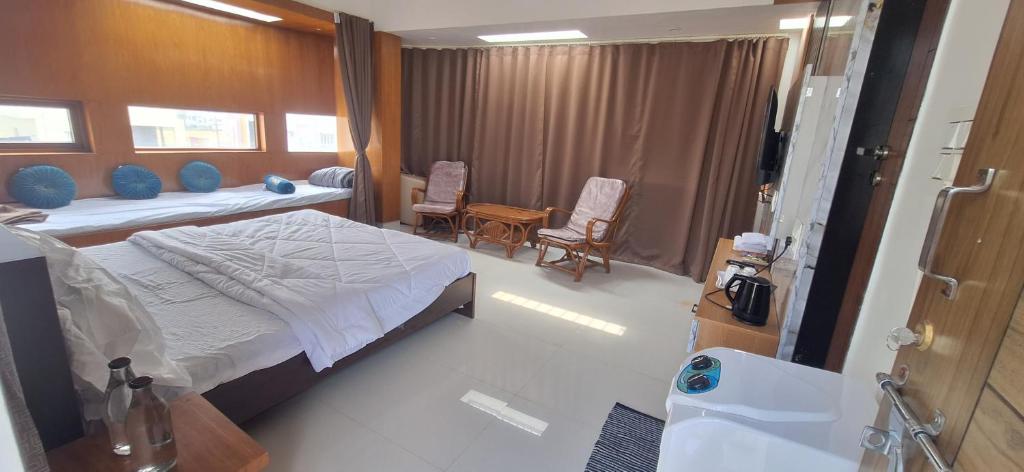 - une chambre avec un lit et deux chaises dans l'établissement Aavasan home stay, à Davangere