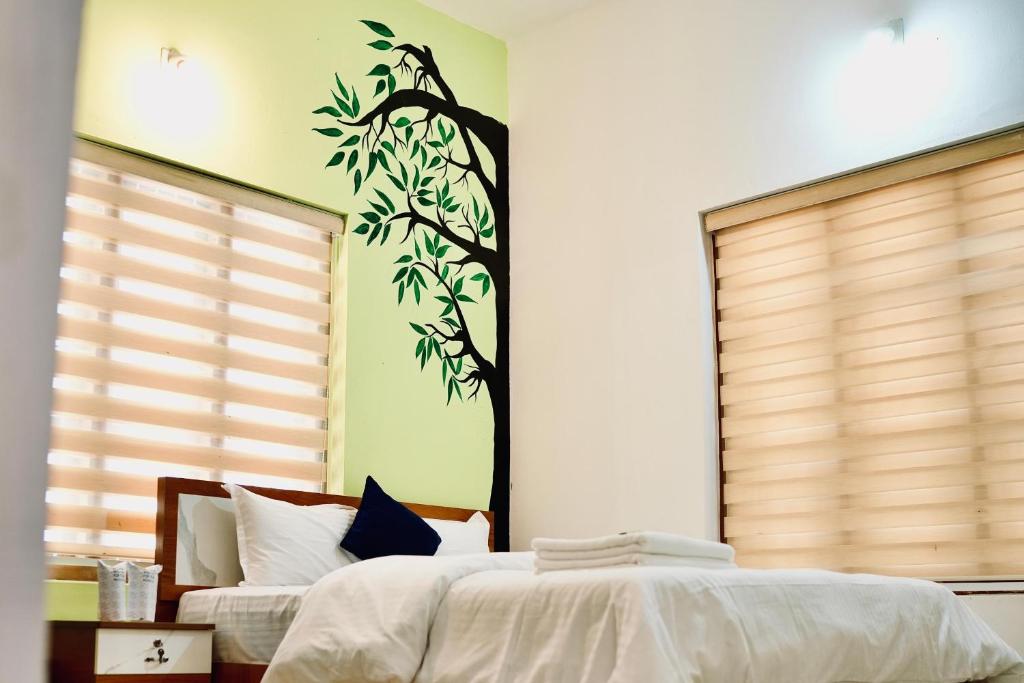 a bedroom with a tree mural on the wall at Nyx Villa in Jāmb
