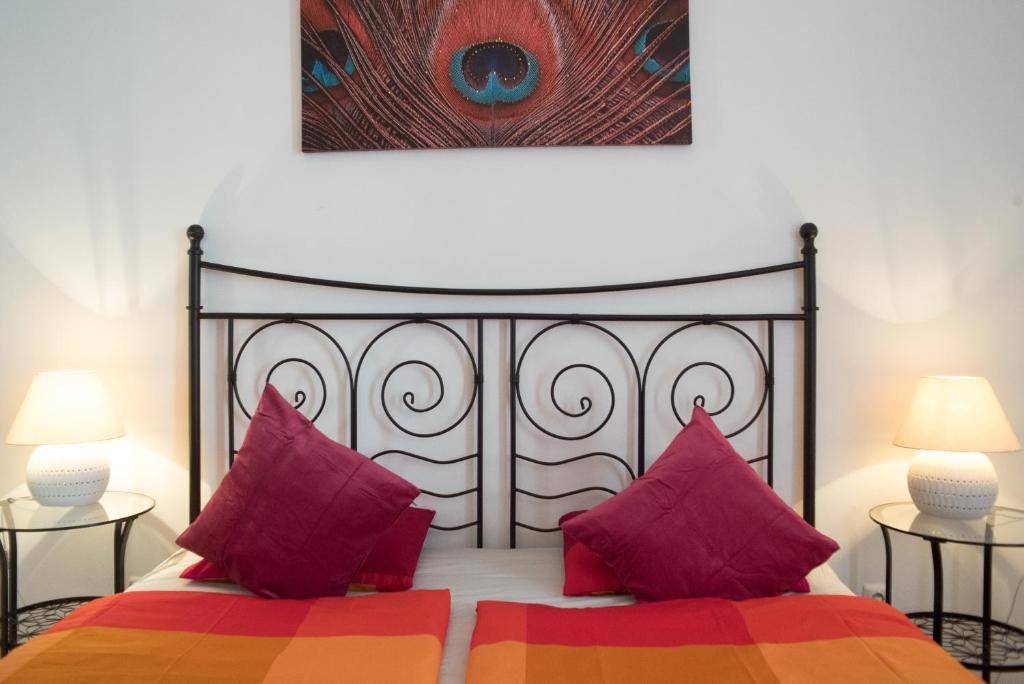 ブダペストにあるApartment with Big Terraceのベッドルーム1室(赤とオレンジの枕が備わるベッド1台付)