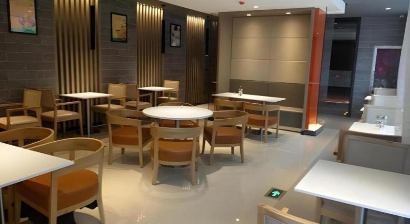 a restaurant with tables and chairs in a room at Jinjiang Inn Select Qingdao West Coast Coach Exhibition Center High-Speed Railway Station in Huangdao