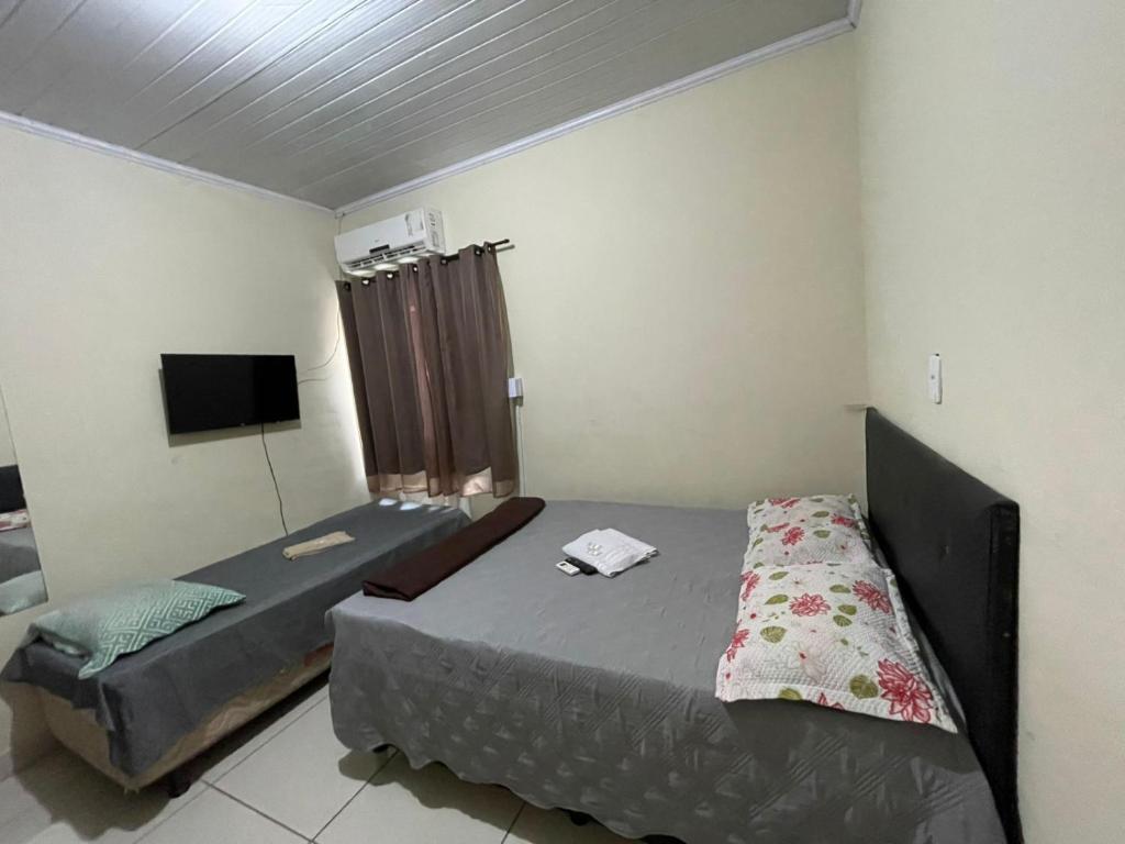 um quarto com duas camas e uma TV de tela plana em Cepop Campos 1 em Campos dos Goytacazes