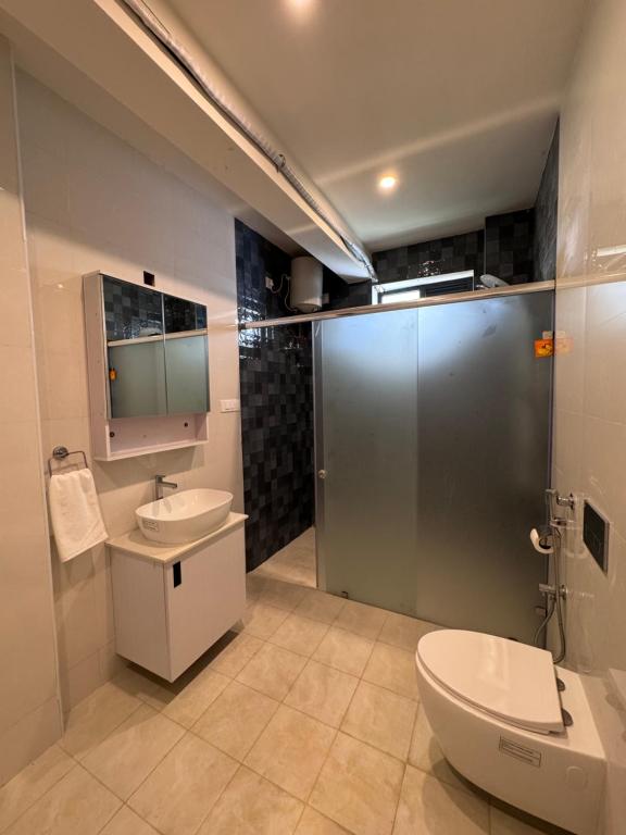 a bathroom with a toilet and a sink and a shower at Turiya Retreat in Auroville
