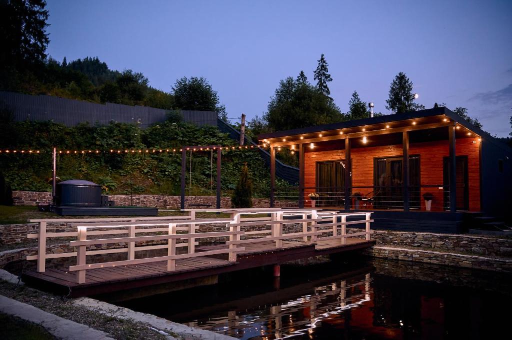 una pequeña cabaña con un puente sobre un estanque en stream housee, en Slavske