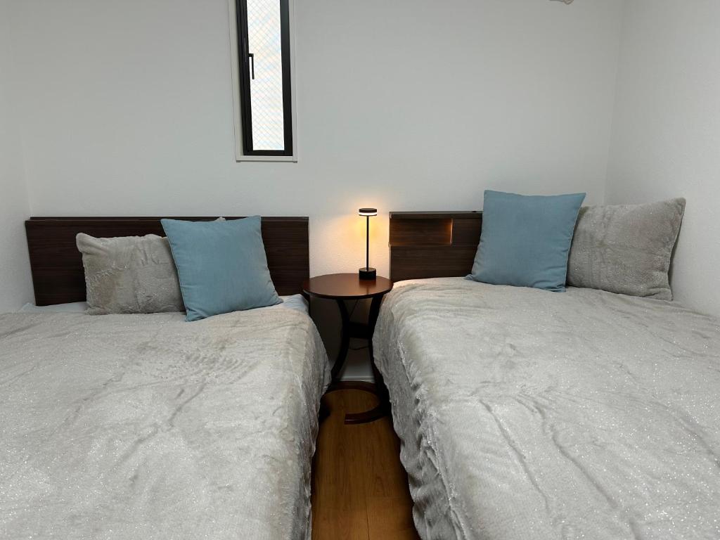 two beds sitting next to each other in a room at 白樺ハウス女性&家族専用 in Chigasaki