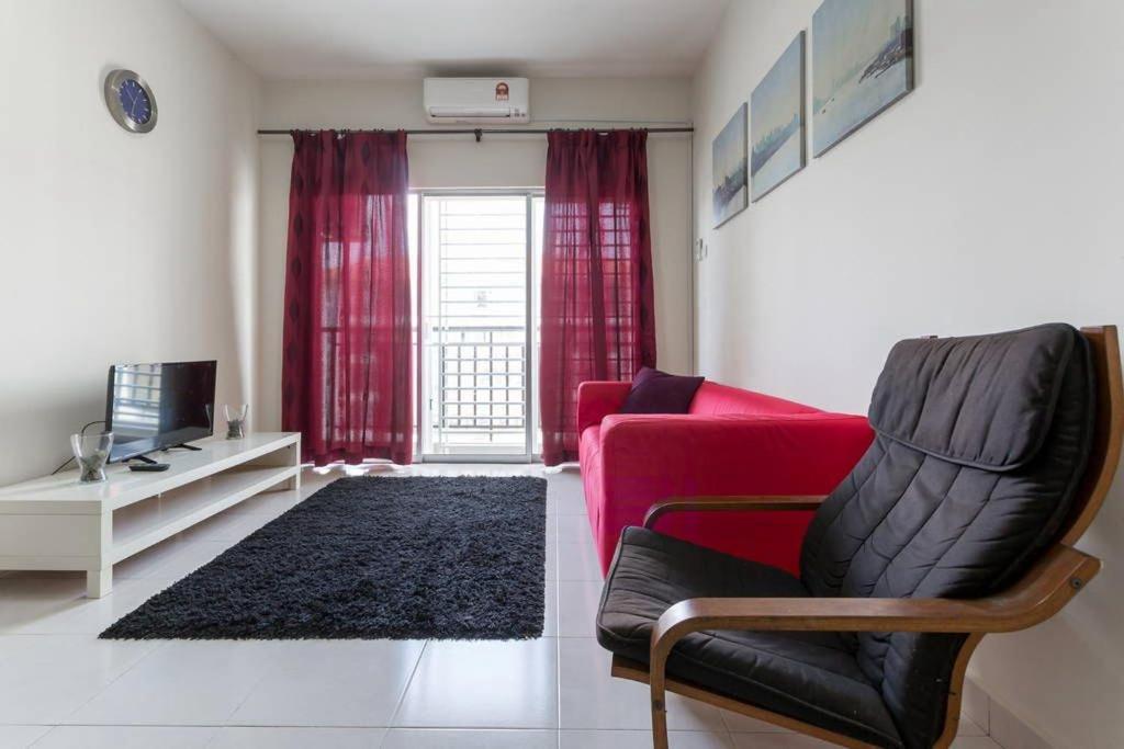 a living room with a red couch and a chair at Ratu Musleem Homestay in Kuala Selangor