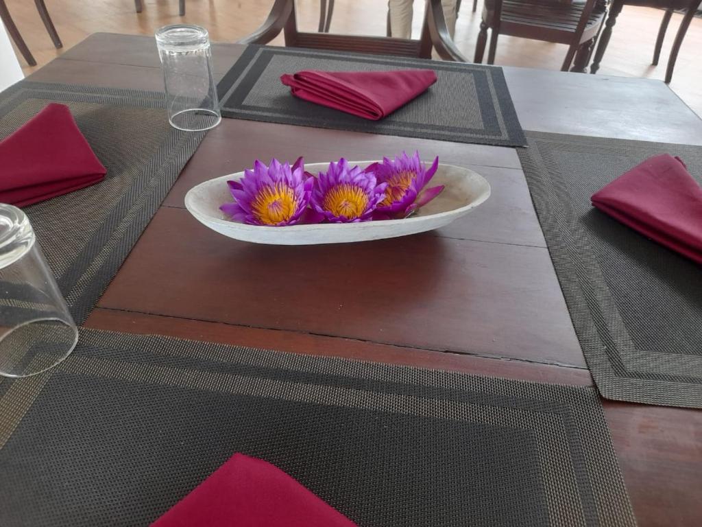 a table with a plate with purple flowers on it at Oga Reach Yala in Lukasgoda