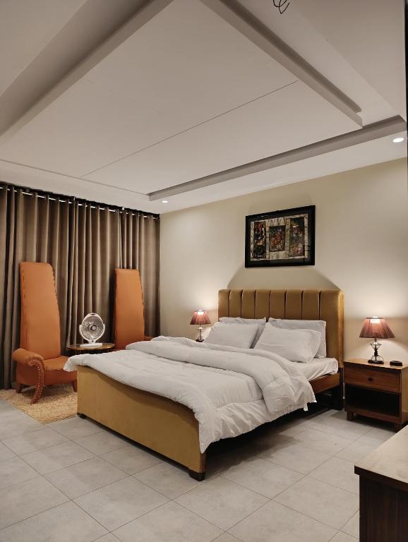 a large bedroom with a large bed and two chairs at Montana Lodges Murree in Murree