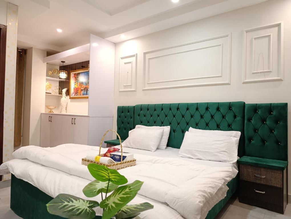 un grand lit avec une tête de lit verte dans une chambre dans l'établissement Montana Lodges Murree, à Murree