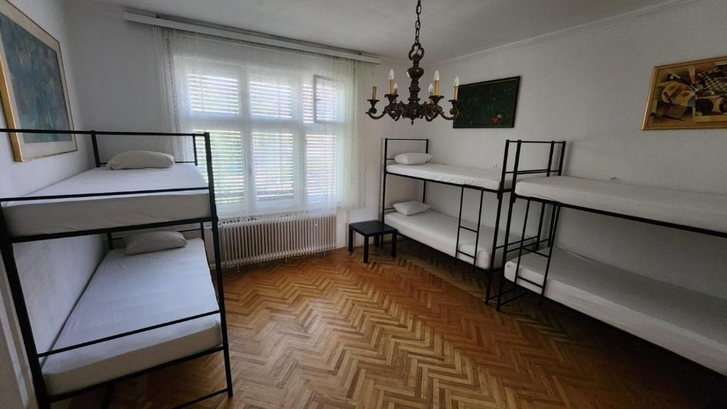 a room with three bunk beds and a window at Folks HOME in Novi Sad