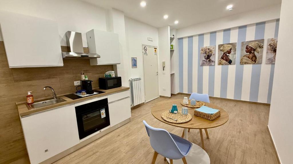 een keuken met een tafel, stoelen en een spoelbak bij Cielo Sereno in Napels