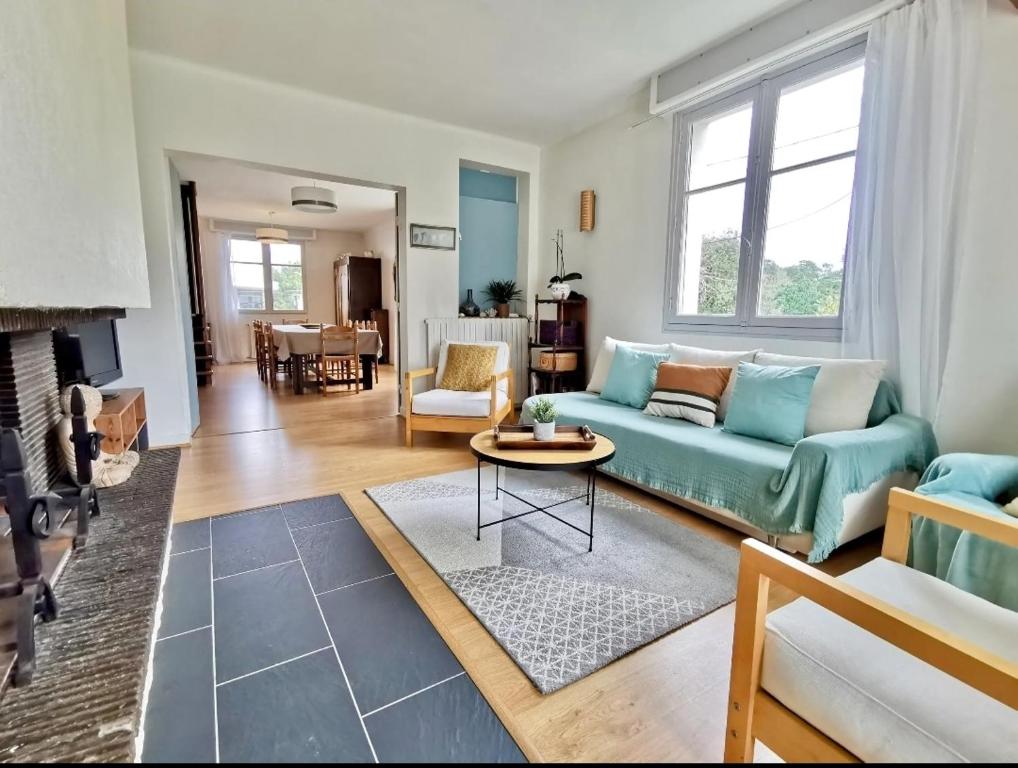 a living room with a blue couch and a table at Charmant dupleix à La Baule, proche de la mer in La Baule