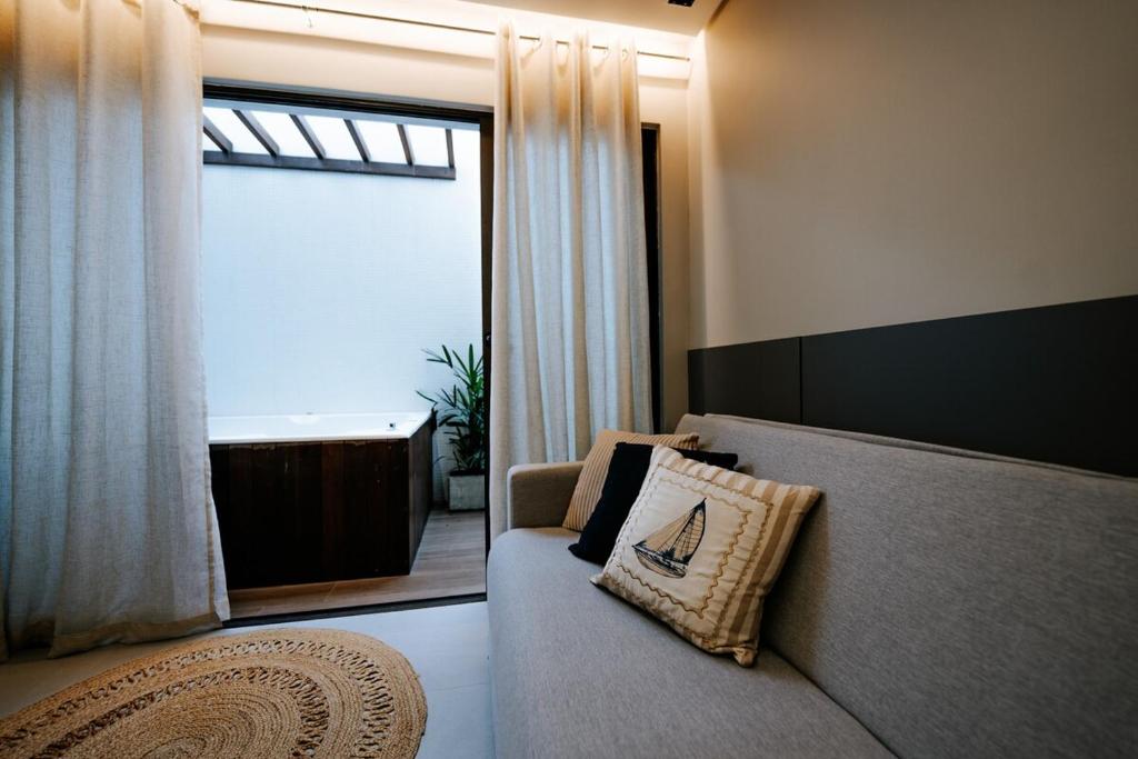 ein Wohnzimmer mit einem Sofa und einer Badewanne in der Unterkunft Experiência a beira mar, Jacuzzi e conforto in Água Boa