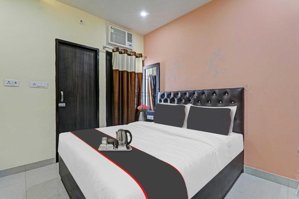 a bedroom with a large bed with a black headboard at Hotel O Unique Stay Inn in Bādshāhnagar