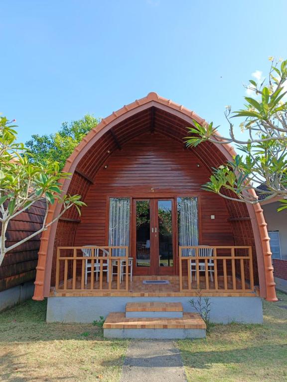 une cabane en bois avec 2 chaises et une terrasse couverte dans l'établissement Homestay Retreat, à Uluwatu