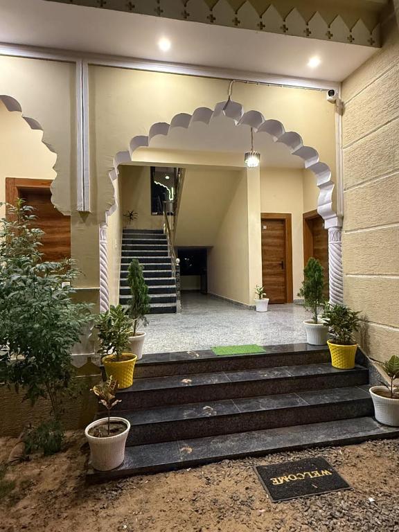 a building with stairs with potted plants in front of it at Braham Niwas Resort in Pushkar