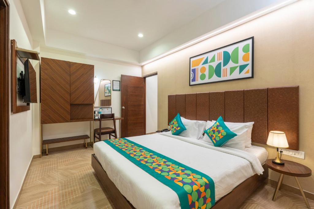 a hotel room with a large bed and a television at Treebo Flora Embassy in Chennai
