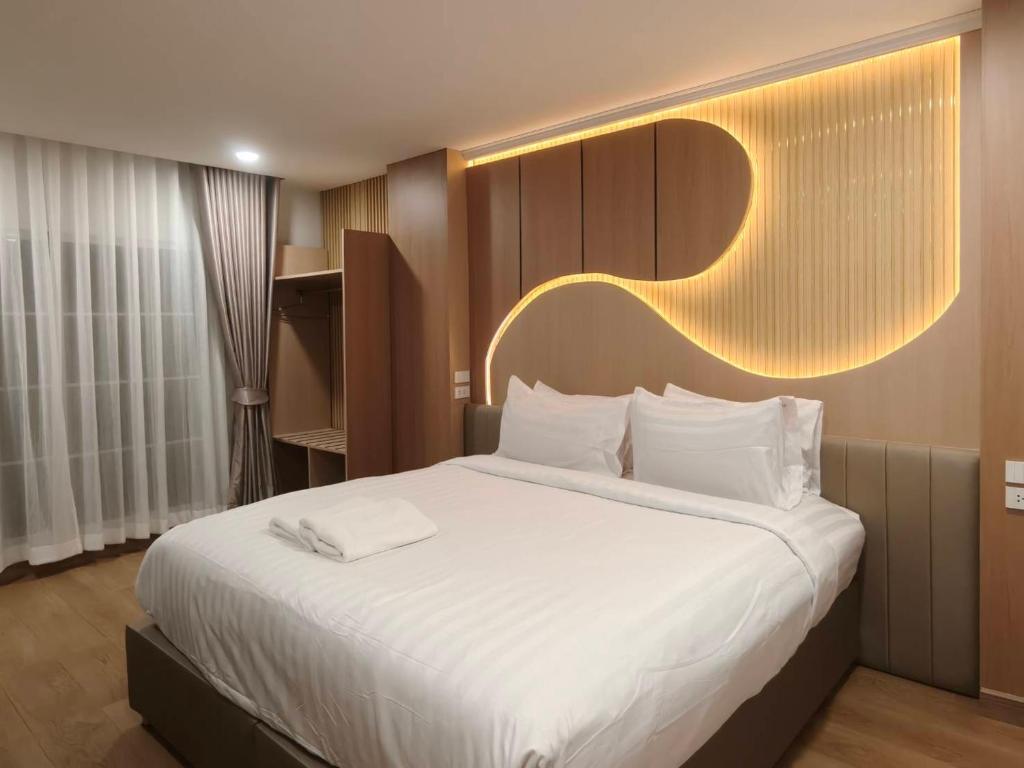 a bedroom with a large bed with a light above it at Chanaplace Lanna in Chiang Mai