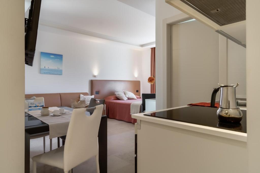 a kitchen with a sink and a living room with a bed at Vela Azzurra Holiday Home in Grottammare