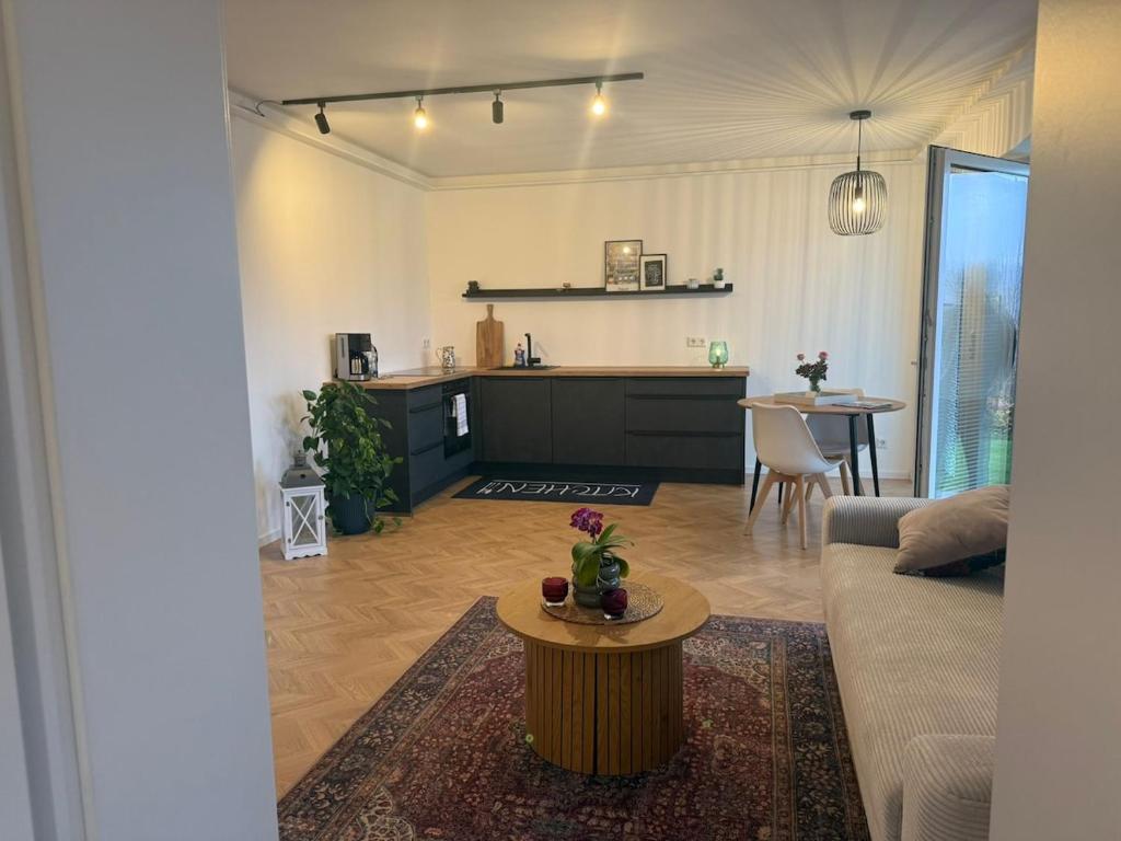 a living room and kitchen with a couch and a table at Moderne Ferienwohnung mit Terrasse und Gartenblick in Hannoversch Münden