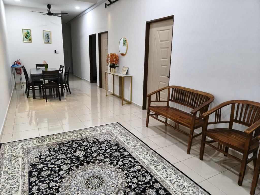 een woonkamer met stoelen en een tapijt op de vloer bij Eiman Homestay in Kuala Terengganu