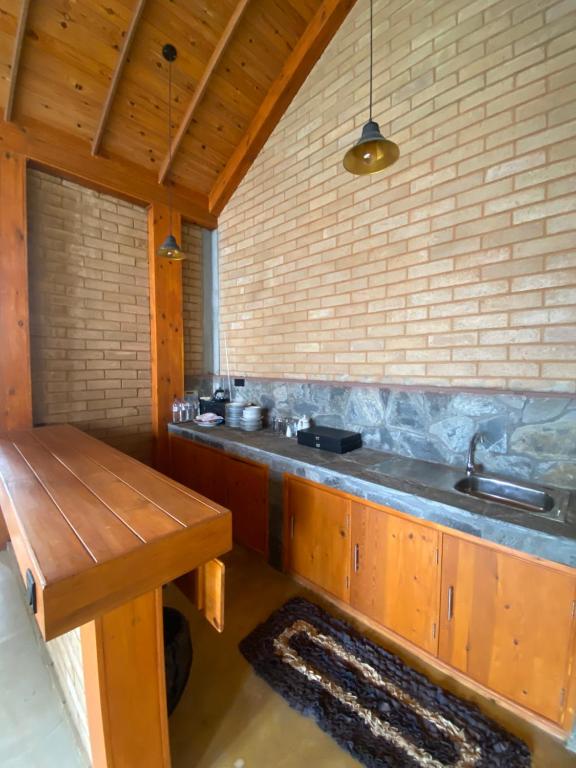 a kitchen with a sink and a wooden table at Mihidugiri Eco lodge in Kandy