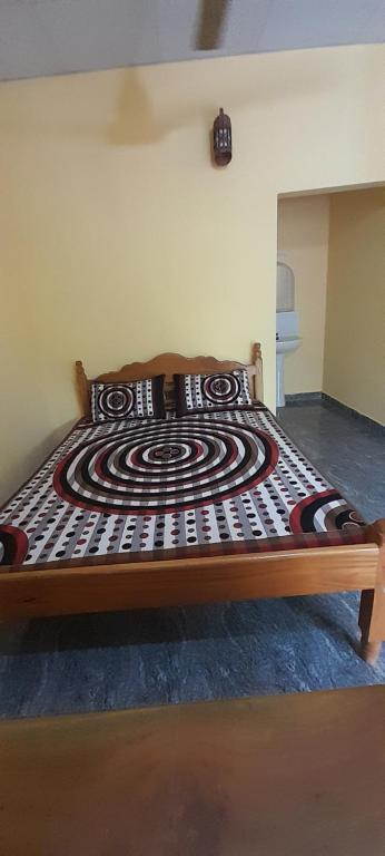 a wooden bed with a design on it in a room at Batti Relax Point Villa & Rooms in Batticaloa
